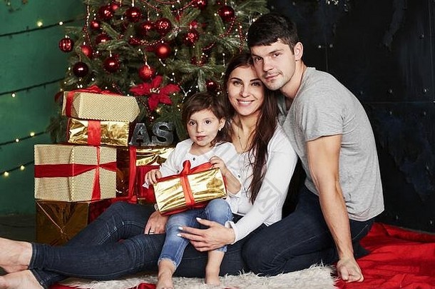 可爱的家庭坐在圣诞节树礼物盒子冬天晚上享受时间支出