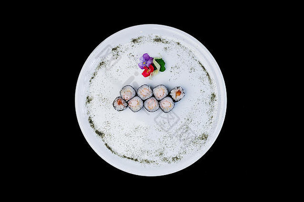 经典寿司卷虾白色轮板装饰小花日本食物前视图孤立的黑色的背景