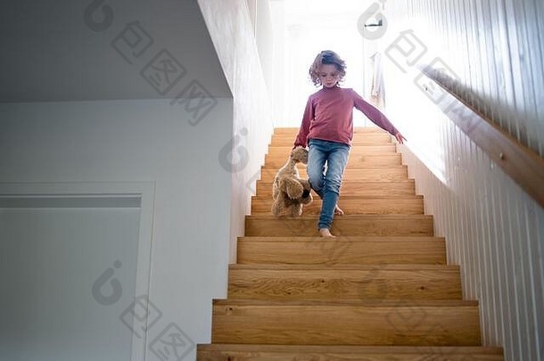 可爱的小女孩走木楼梯在室内首页