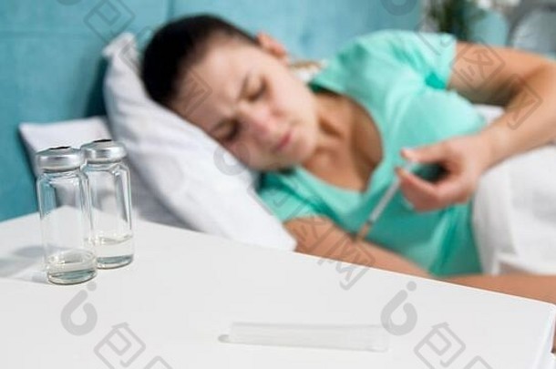 模糊图像生病的女人糖尿病说谎床上使胰岛素注射注射器
