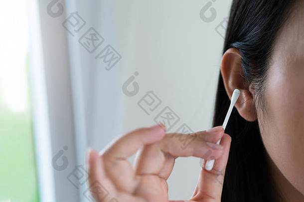 女人清洁耳朵棉花拭子医疗保健耳朵清洁概念