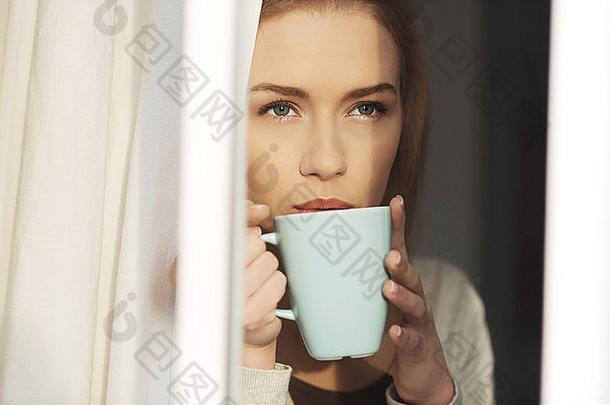 美丽的高加索人女人喝热咖啡茶窗口室内背景