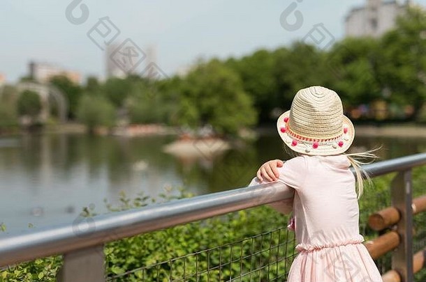 后视图蹒跚学步的女孩湖树公园在户外