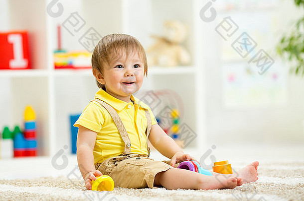 可爱的孩子玩玩具坐着地板上