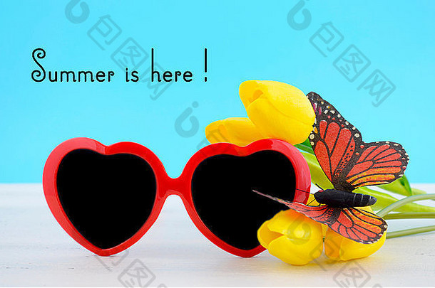 夏天概念红色的心形状太阳镜蝴蝶黄色的花白色木表格天空蓝色的后台支持