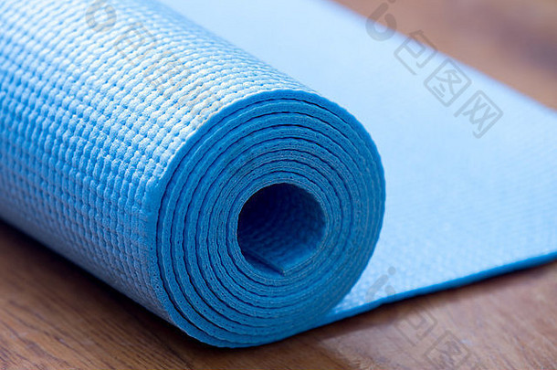 关闭滚蓝色的瑜伽普拉提席地板上健康的生活适合概念