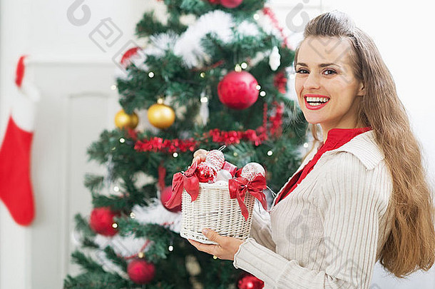 微笑年轻的女人圣诞节装饰圣诞节树