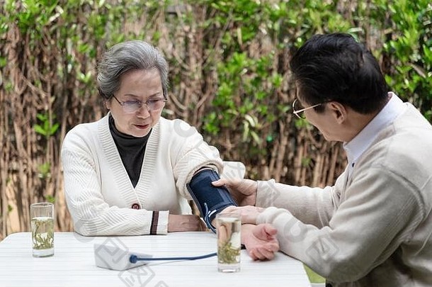 亚洲上了年纪的夫妇测量血压力