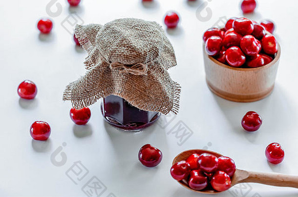 红色的成熟的樱桃小时Jar木勺子白色背景平躺食物概念
