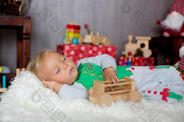 甜蜜的蹒跚学步的孩子男孩睡觉很多玩具穿着精灵克里斯特马斯装饰