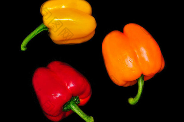 生动的色彩斑斓的闪亮的辣椒黑色的背景蔬菜形成圆红色的黄色的橙色充满活力的颜色