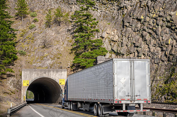 大钻井平台长拉蓝色的美国半卡车<strong>运输商</strong>业货物冷藏半预告片运行隧道狭窄的路