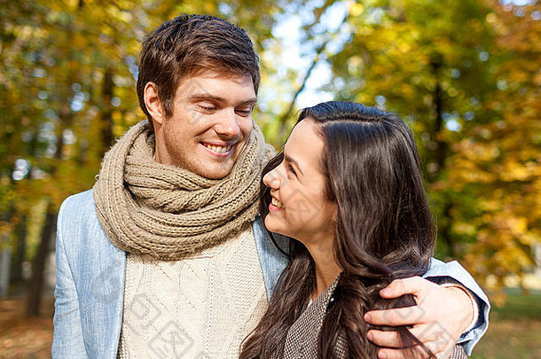微笑夫妇拥抱秋天公园