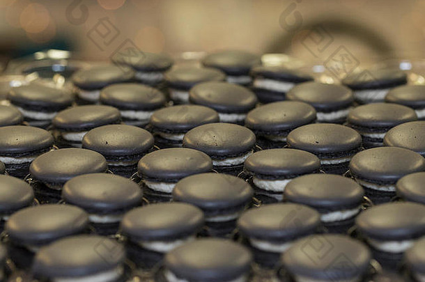 行手工制作的黑色的蛋白酥皮法国马卡龙白色奶油工匠食物市场