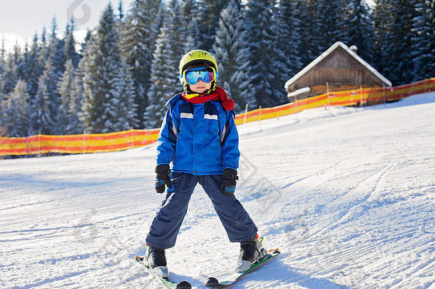 可爱的男孩滑雪幸福的奥地利滑雪度假胜地山冬季