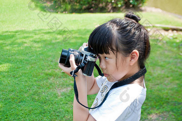 年女孩采取照片单镜头反射相机户外公园孩子有趣的练习摄影