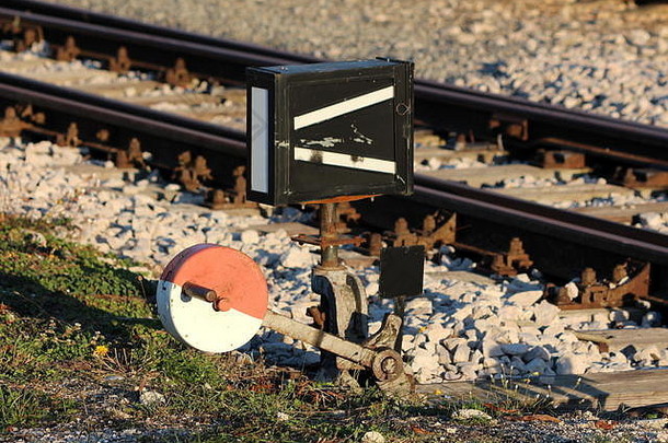 强大的部分生锈的红色的白色金属铁路<strong>开关机</strong>制安装木董事会铁路跟踪包围砾石草