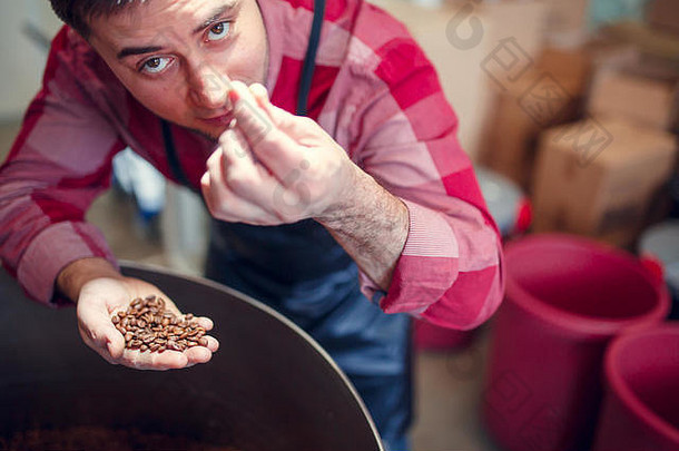 图片年轻的男人。咖啡豆子手烘烤器