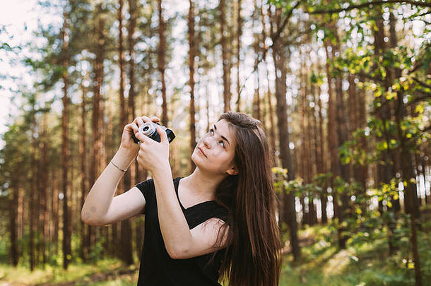 快乐红发高加索人女孩年轻的女人摄影师采取图片复古的古董电影相机夏天绿色前部