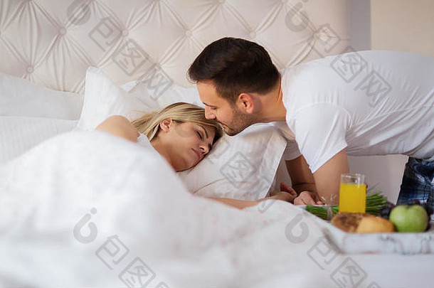 浪漫的丈夫醒着的妻子早餐床上