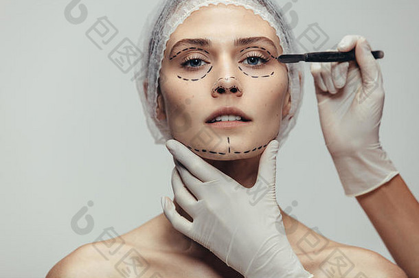 女人医疗头饰虚线行画脸美容师持有手术刀塑料手术女人反老化脸生活