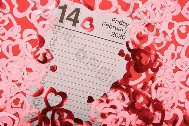 日历页面开放情人节一天包围闪亮的心红色的背景