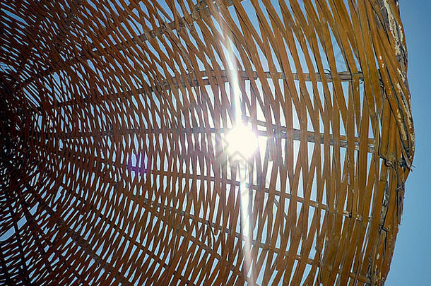 太阳闪亮的柳条海滩阳伞