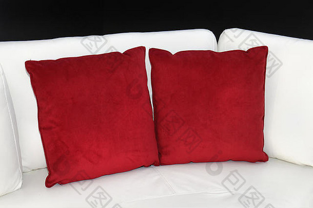 红色的装饰枕头角落里白色皮革沙发