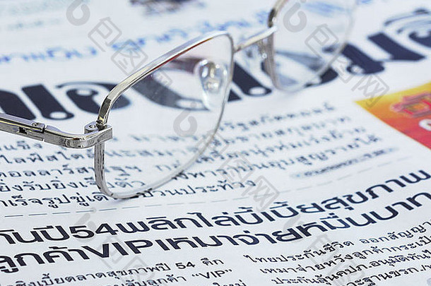 特写镜头泰国语言报纸一对眼镜