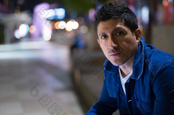 拉美裔男人。等待城市街道晚上