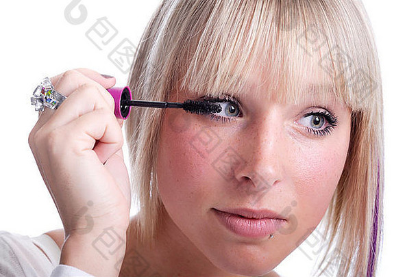 美丽的年轻的女人应用睫毛膏孤立的白色背景