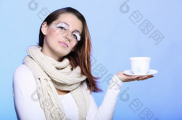 时尚女人时尚的冬天化妆持有杯拿铁咖啡热喝时间享受Copyspace蓝色的背景