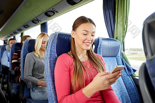 快乐女人坐着旅行公共<strong>汽</strong>车智能手机