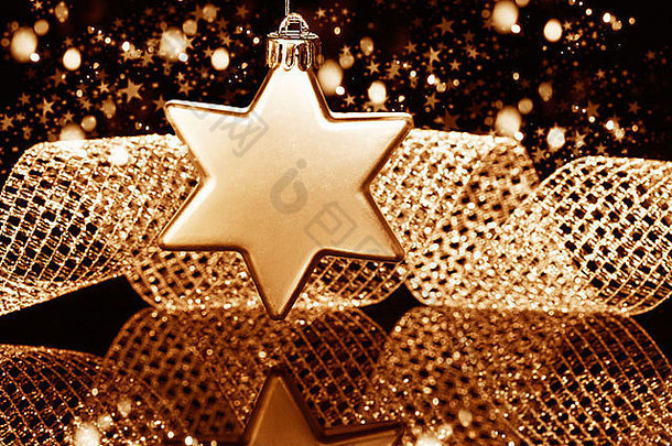 圣诞节球明星形状前面金属丝带闪闪发光的金黑色的背景