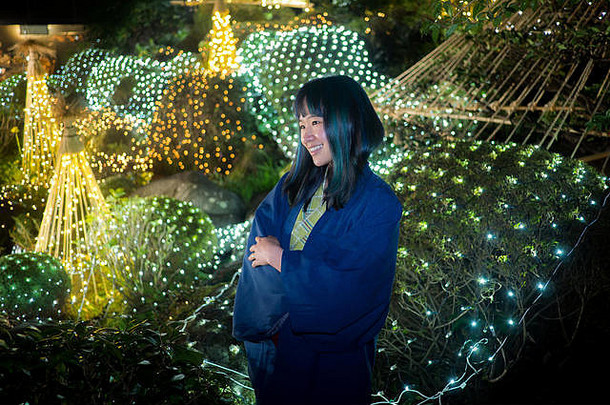 美丽的年轻的女人yukata摆姿势日本花园照亮灯