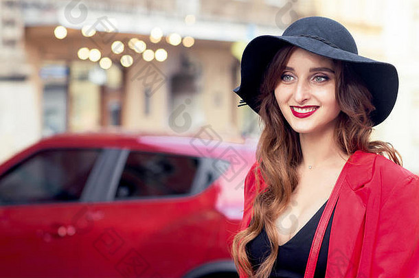 快乐微笑成人女孩黑色的他红色的车年轻的漂亮的女人黑色的他背景红色的车在户外