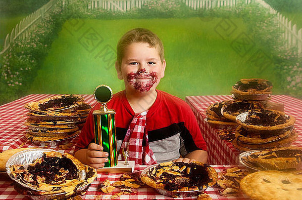 胖乎乎的男孩结束馅饼吃比赛赢得金牌