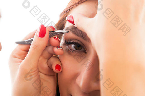 女人的眉摘眉毛红发女人实现理想的形状美沙龙一边视图眉修正程序