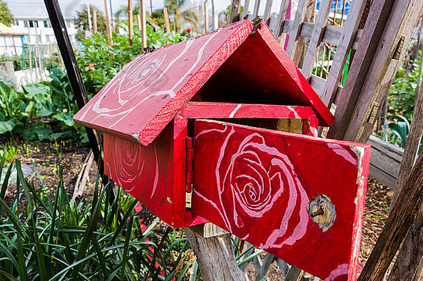 红色的木信箱白色画花模式屋顶通过发现社区花园