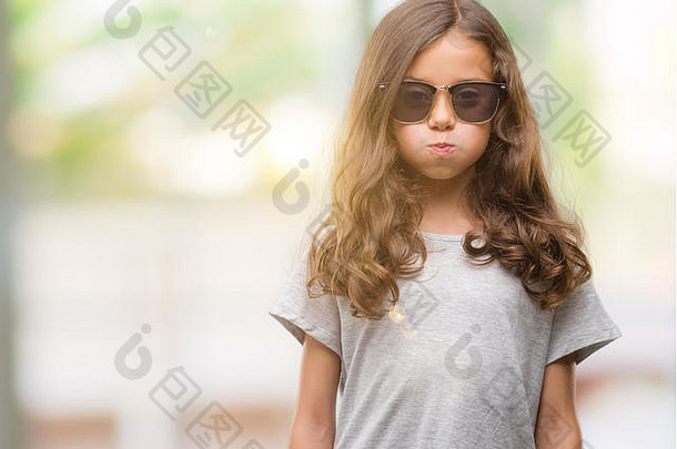 浅黑肤色的女人拉美裔女孩穿太阳镜吸烟脸颊有趣的脸口膨胀的空气疯狂的表达式