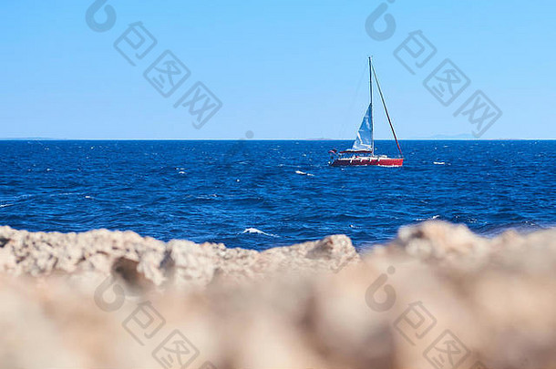 游艇航行蓝色的海岩石前景