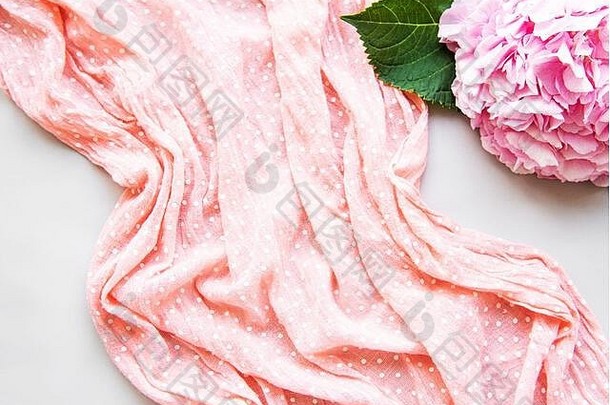 粉红色的围巾波尔卡点折叠白色背景粉红色的绣球花
