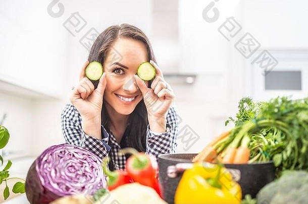 快乐的年轻的女人持有片黄瓜厨房饮食蔬菜希斯概念