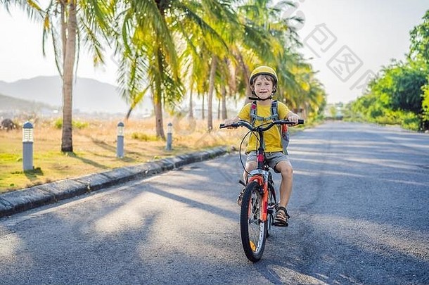 活跃的学校孩子男孩安全头盔骑自行车背包阳光明媚的一天快乐孩子骑自行车<strong>学校安全</strong>孩子们在户外