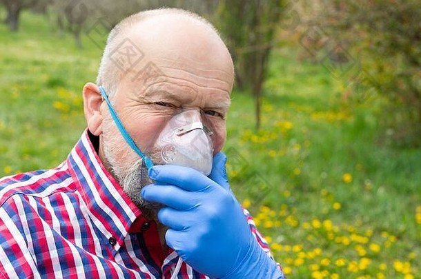 肖像高级男人。氧气面具支出时间在户外花园冠状病毒检疫