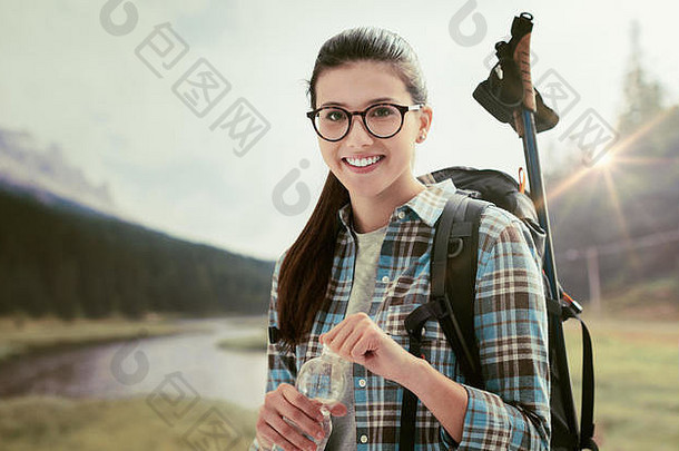 女孩徒步旅行在户外山持有水瓶携带背包徒步旅行波兰