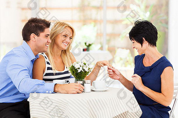 快乐年轻的女人未婚夫显示订婚环妈妈。