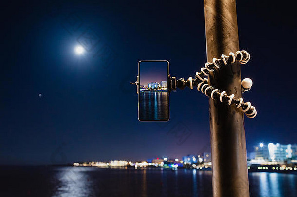 智能手机灵活的三脚架使照片海晚上景观