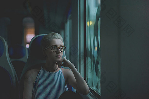 年轻的美丽的女人坐着<strong>火车</strong>窗口沉思的深思熟虑的通勤概念