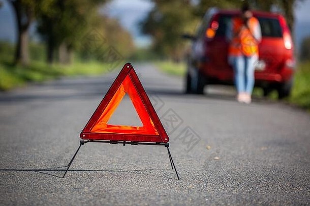 生气年轻的女人路痛苦情况设置警告三角形调用援助